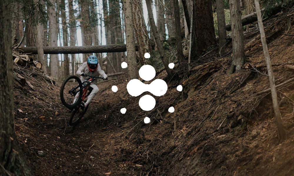Photo of a mountain biker in action. There is an icon on top of the image.
